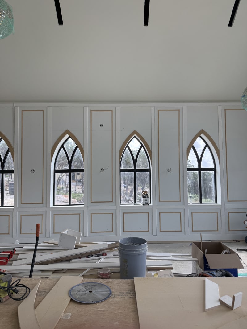 Paneled wainscoting and arched windows being finished inside The Chapel at Wimberley sanctuary